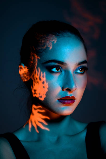 istock Woman with fiery light projection on face 2150303316