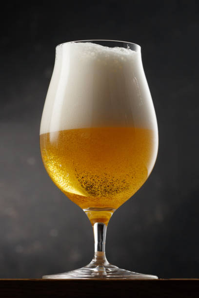 istock Glass with light golden beer on a gray background 2150303613
