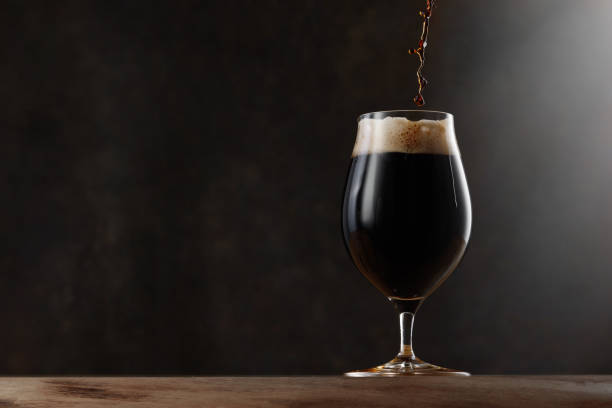 istock Dark beer jet pouring into a beer glass. 2150303635