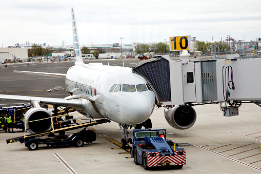 Airplane is towed by tug tractor at Pearson International Airport in Toronto, Ontario, Canada on a sunny day.