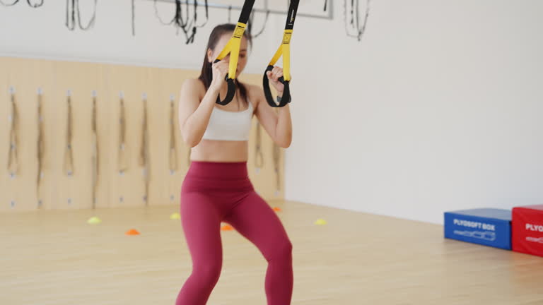 A woman is exercising with a set of resistance bands