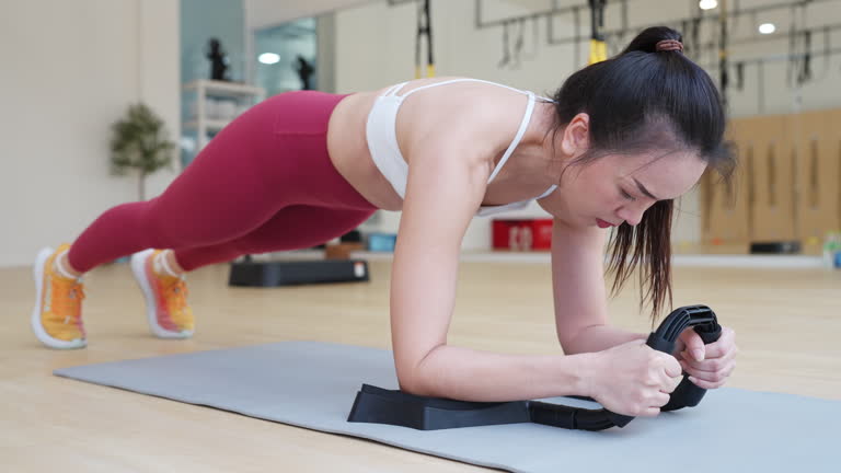 A woman is doing a plank exercise on a mat
