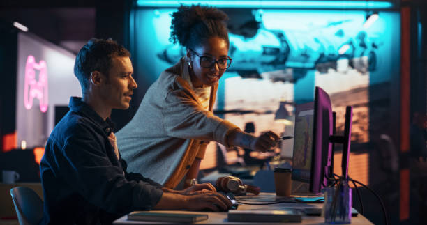 istock Portrait of Black Creative Director and Male Developer Talking About Work in Creative Agency. Two Stylish Diverse Employees Discussing Character Design on Computer in Game Development Company 2150307283