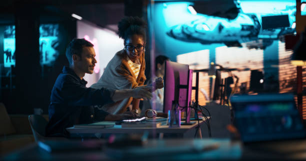 istock Portrait of Black Creative Director Giving Instructions on 3D Game Visuals to Male Developer in Creative Agency. Two Stylish Diverse Employees Discussing Design on Computer in Game Development Company 2150307337