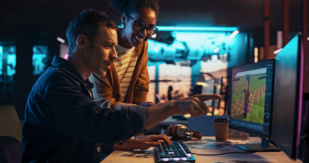 istock Portrait of Young Creative Director and Female Designer Talking About Work, Making Changes on Project. Two Stylish Diverse Employees Discussing Level Landscape on Computer in Game Development Company 2150307748