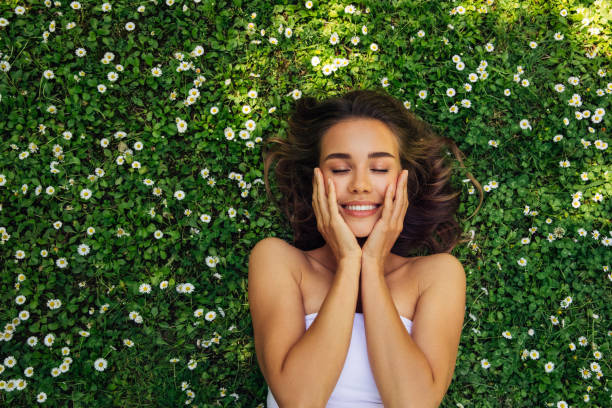 istock Smiling Young Woman Lying Down On Grass 2150307897