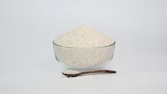 White rice grains in a clear container, white background, isolated