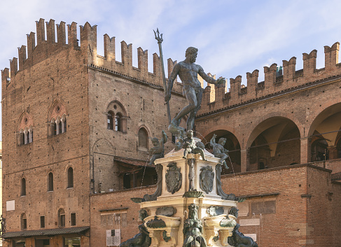Neptune Fountain, an emblem of Bologna, rises in Piazza Maggiore with the historical Palazzo del Podesta looming in the backdrop