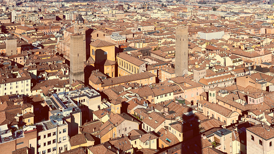 Bologna city center is known for its famous medieval towers. This aerial view captures the dense terracotta rooftops surrounding the iconic structures in the heart of the city
