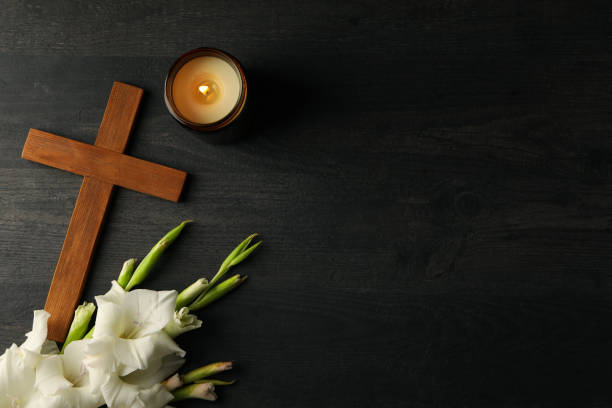 istock Candle, flowers and cross on wooden background, space for text 2150310404