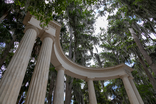 A sculpture in the form of a Greek theatre provides a window through the trees over Lake Maitland in Winter Park, Florida.