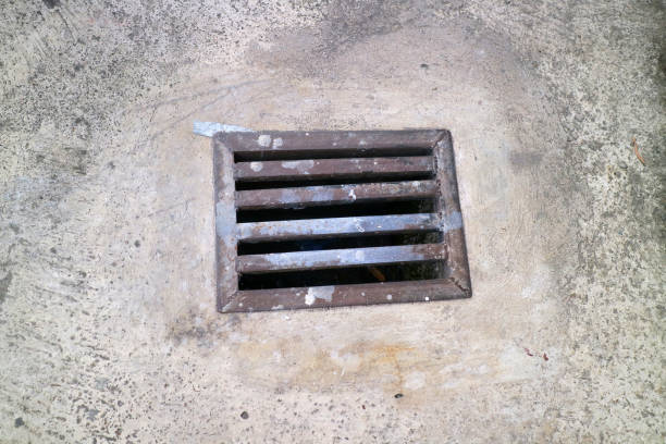 istock an iron gutter cover, with a rust color. Box shaped. on a concrete road 2150313692