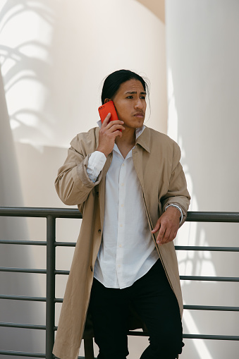 A young Ecuadorian man dressed in urban fashion takes a phone call