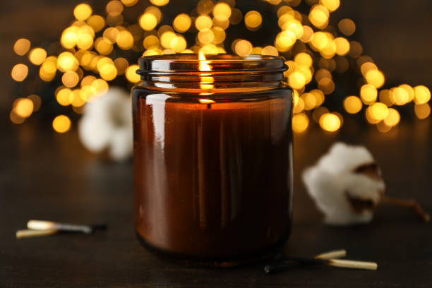 istock Candle on wooden table on dark background, close up 2150315044