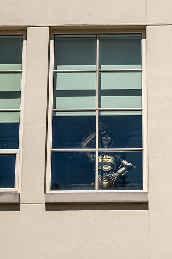 C3PO waving hand from window of the Lucas film building in San Francisco during springtime day