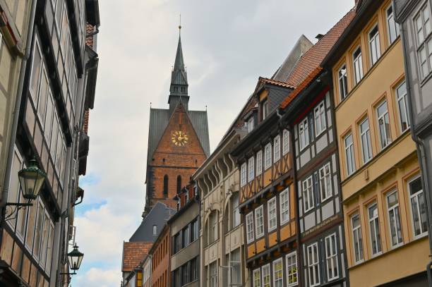 An exterior view of a tall church tower with spire in the city of Hanover in Germany.