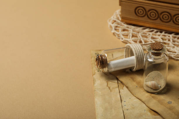 istock Columbus Day. Old envelopes and a glass bottle with a letter inside 2150317396