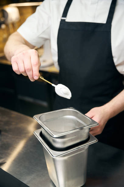 istock Partial chef holding marshmallow on tree branch while cooking dish in restaurant 2150321422