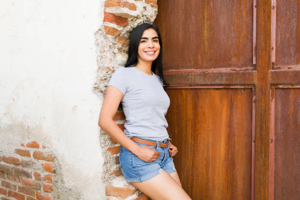 istock Confident latin woman in a plain grey t-shirt, smiling against a rustic textured background - ideal for mockups! 2150321577