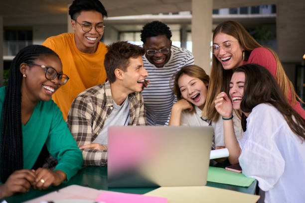 istock Group of young diverse students people laughing using laptop in the cafeteria on university campus 2150322046