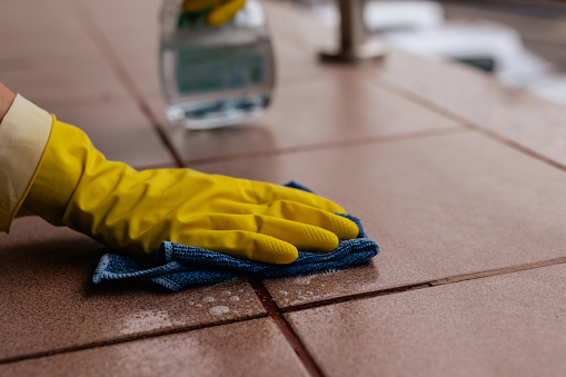 Woman cleaning tile floors outdoors, spring cleaning