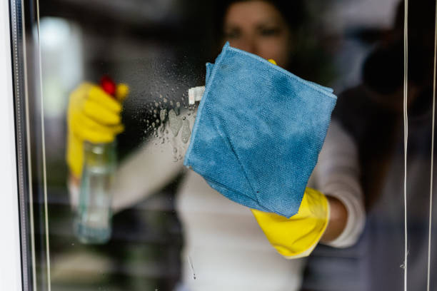 istock Young woman washing window 2150323342