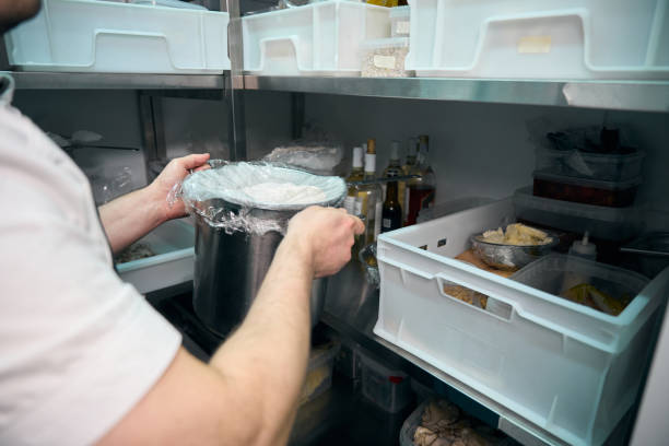 istock Chef putting dish in saucepan on shelf in refrigerator storage in restaurant 2150323730