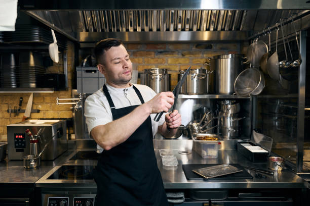 istock Caucasian male chef sharpening knife with sharpener on kitchen in restaurant 2150323737
