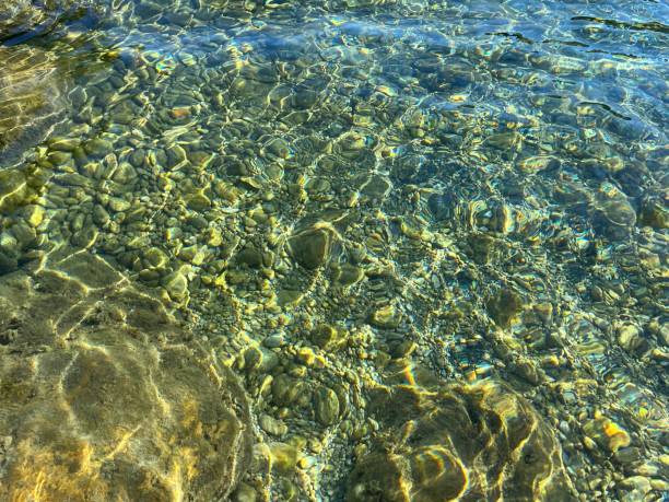 istock Sea stones and pebbles in transparent clear water. 2150324209
