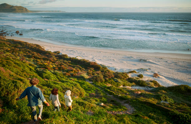 istock Mature women walking down a path to a scenic beach during a road trip 2150324712