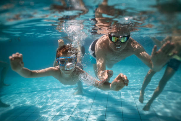 istock Senior man enjoying swimming underwater with grandson 2150325085