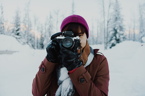 Young man taking pictures in the snow In winter in Alaska, America