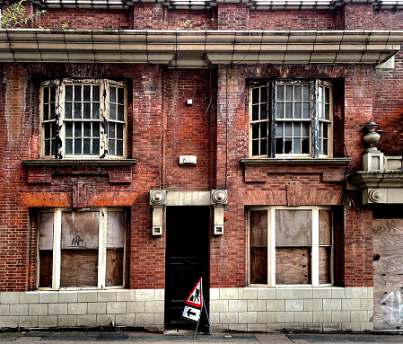 Old derelict building with damp walls and broken windows, in Leicester. October 2021