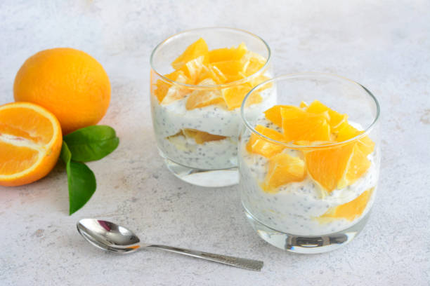 istock two glasses of yogurt with oranges and a spoon next to them 2150327150