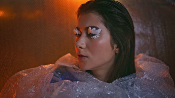 istock Unique style woman looking thoughtfully in bubble pack revealing petal eyelashes 2150330776