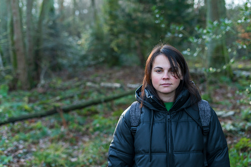 Young woman in the forest looking at the camera with a serious expression