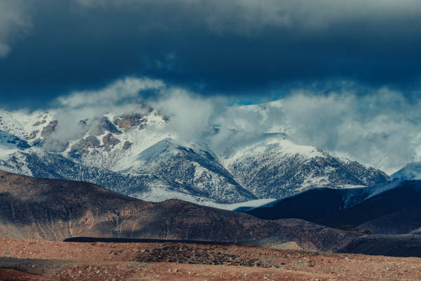 Picturesque mountain landscape with snowy peaks and clouds