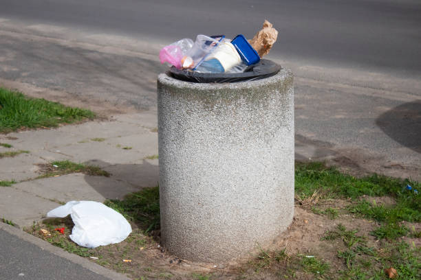 istock Public trash can on a city street filled with garbage 2150334683
