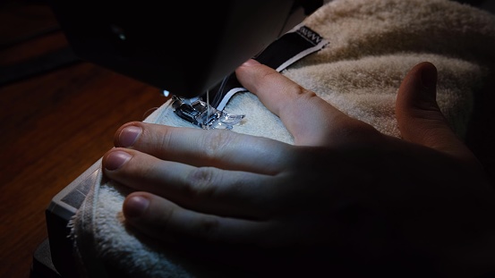Sewing Machine Needle in Motion. Close-up of sewing machine needle rapidly moves up. The tailor sews towel on the sewing workshop. The process of sewing fabric. 4K 300mb s