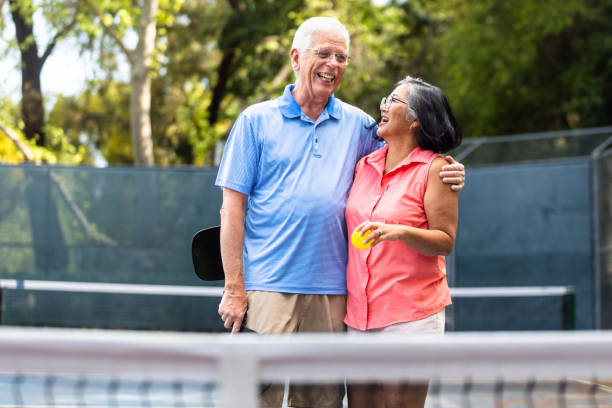 istock Senior couple playing pickleball with friends 2150336540