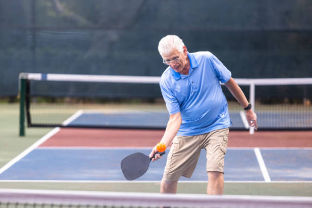 istock Senior couple playing pickleball with friends 2150336576