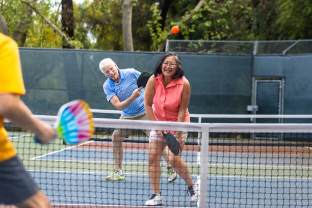 istock Senior couple playing pickleball with friends 2150336676