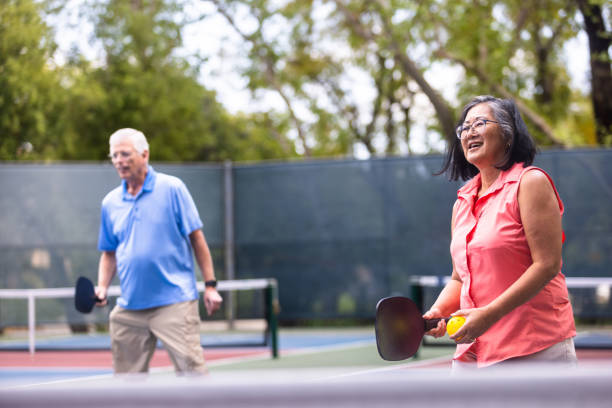 istock Senior couple playing pickleball with friends 2150336680