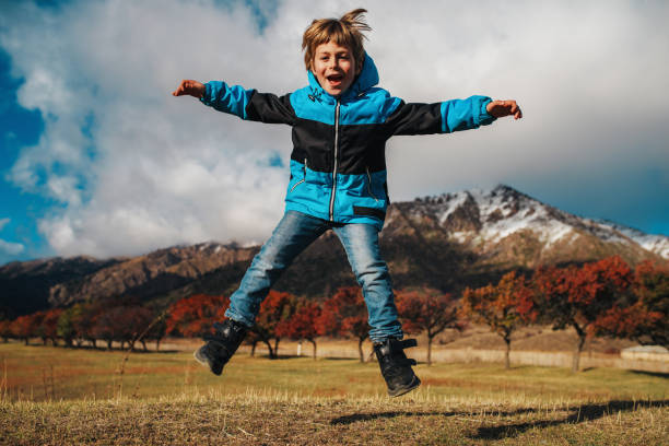 istock Happy boy jumping on mountains background in autumn 2150336688