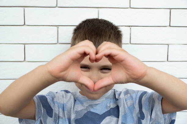 istock Happy boy making a heart shape with his hands. 2150336872