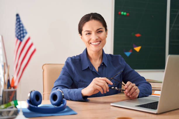 istock Merry school teacher enjoying remote education at school 2150338252