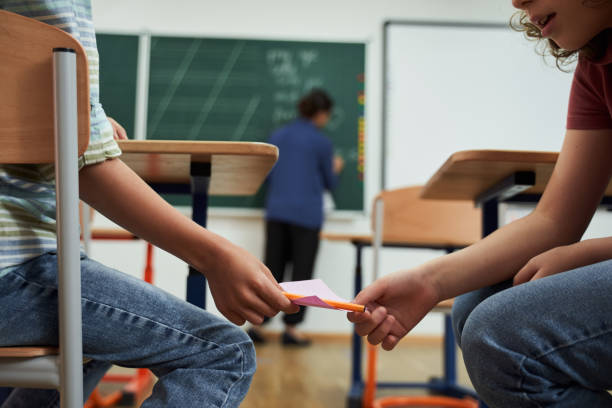 istock Two naughty boys cheeting during school exam 2150338287