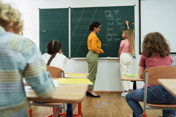 istock Cheerful girl writing on chalkboard during lesson 2150338297