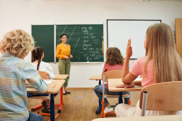 istock Smiling female teacher at blackboard during lesson 2150338300