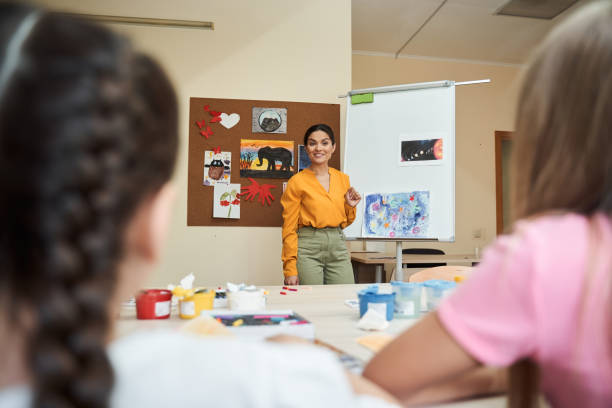 Smiling beautiful woman teaching art for children